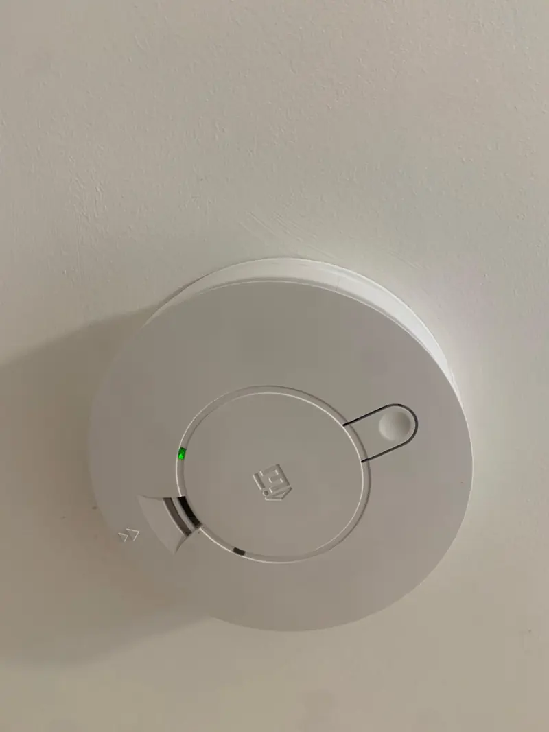 New Aico mains smoke alarm on a ceiling, green power light on